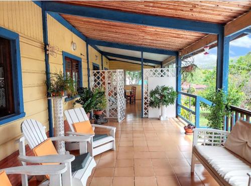a porch of a house with chairs and a table at Appartement confortable à Le François avec piscine partagée in Le François