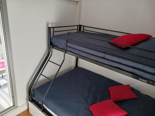 - 2 lits superposés dans une chambre avec un oreiller rouge dans l'établissement le cap d'agde, Port Raphaël, apt 5 pers, clim, piscine, au Cap d'Agde