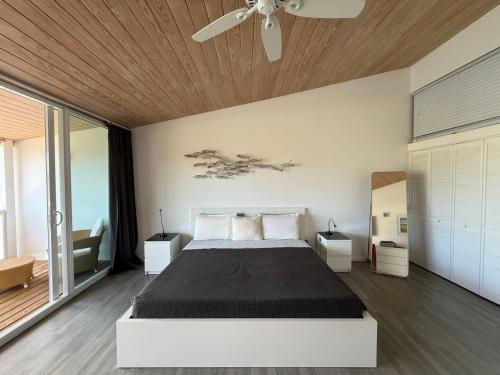 Jolly HarbourにあるLuxury Waterfront Villa 249C South Beachのベッドと天井扇風機のある寝室