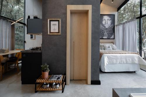 a bedroom with a bed and a kitchen and a table at Arau Cabana Cheiro de Mato in Flores da Cunha