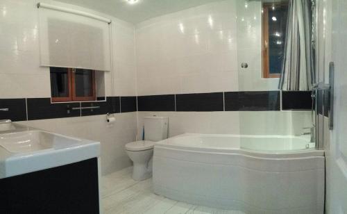 une salle de bain avec une baignoire, des toilettes et un lavabo dans l'établissement La Chapelle - Private Heated Pool, Village Centre, à Loubès-Bernac