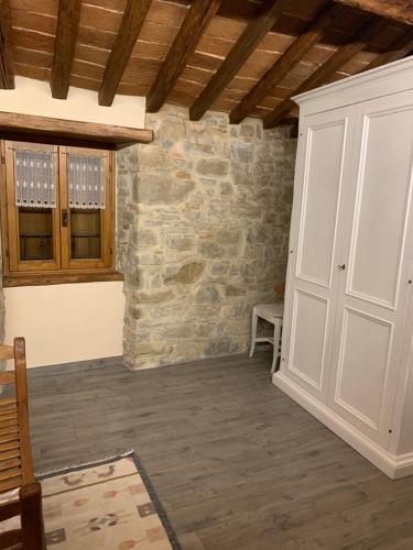 a room with a white door and a stone wall at Casa di Adele in Pratovecchio