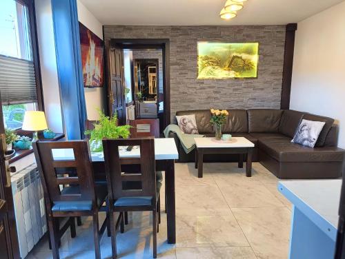 a living room with a couch and a table at Pokoje i apartamenty u Sabiny - DOSTĘP DO JACUZZI TYLKO W WYBRANYCH OPCJACH sprawdź poniżej szczegóły rezerwacji in Szczawnica