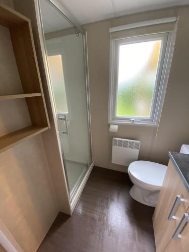 une salle de bain avec toilettes et fenêtre dans l'établissement MobilHome Camping Deauville, à Saint-Arnoult