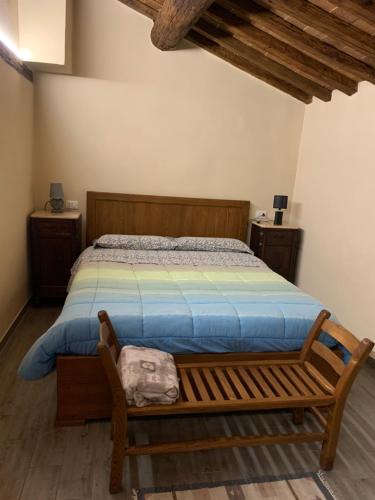 a bedroom with a bed and a wooden bench at Casa di Adele in Pratovecchio
