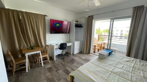 a bedroom with a bed and a desk and a window at Residencial Paraiso in Bayahibe