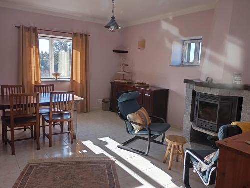 a living room with a table and chairs and a fireplace at Quinta da Barroca do Cabo in Ázere