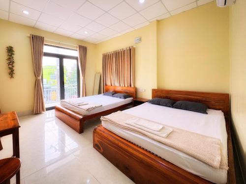ハティエンにあるHoa Dũng homestayのベッド2台と窓のある寝室
