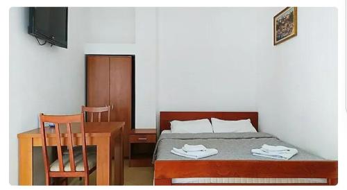 sypialnia z łóżkiem, biurkiem i telewizorem w obiekcie Дарина w mieście Igalo