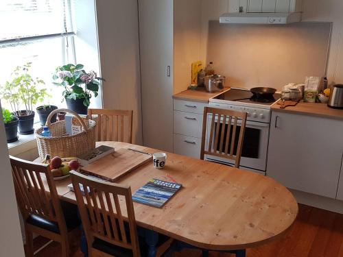 una cucina con un tavolo di legno e un tavolo e sedie di Trondhjemsvegen a Gjøvik