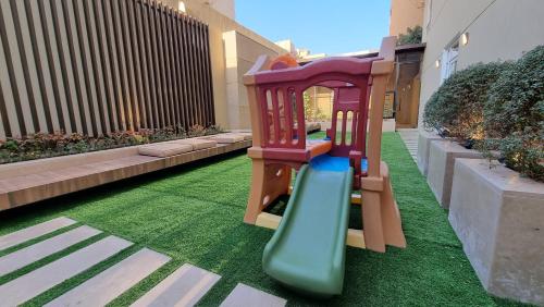a playground with a slide on the grass at Villa 55 in 6th Of October