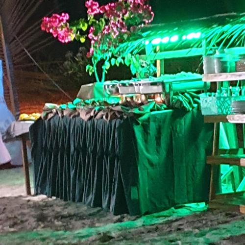 a table with a green cloth and flowers on it at La Tranquilidad Twin Beach Resort in Dipnay