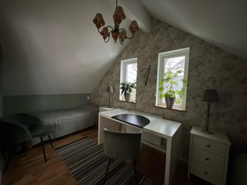 a room with a desk and a bed and two windows at Kullsbacka in Skanör med Falsterbo
