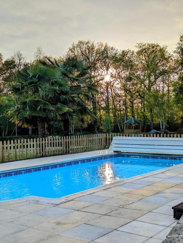 une piscine dans une cour clôturée dans l'établissement La Maison du petit lac, à Messé