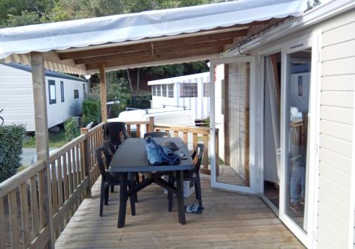 un patio avec une table et des chaises sur une terrasse dans l'établissement Mobil home Charente maritime, à Ronce-les-Bains