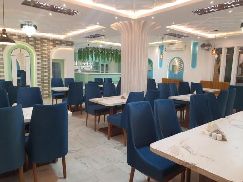a dining room with tables and blue chairs at HOTEL DEO VOLENTE in Sivasagar