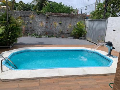 a pool with a water fountain in a yard at Pousada - Aconchego do Sol in João Pessoa