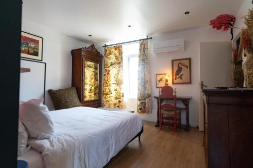 a bedroom with a bed and a window and a desk at Maison Georges in Tourcoing