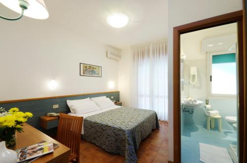 een hotelkamer met een bed en een badkamer bij Hotel Milano in Eraclea Mare