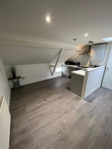 an empty room with a kitchen and wooden floor at Charming Town Retreat in Hedon