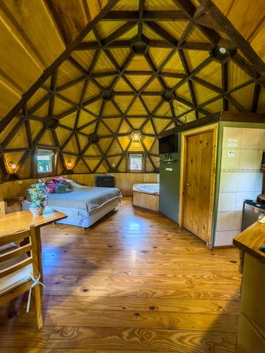a large room with a bed and a refrigerator at Domos Puelo in Lago Puelo