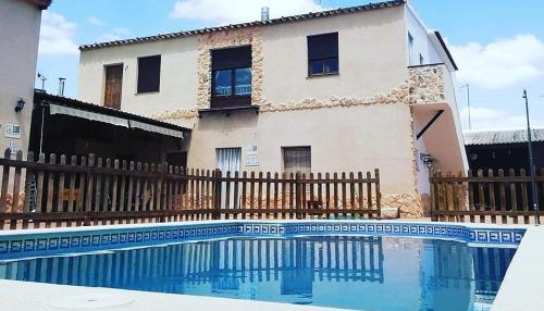 ein Haus und ein Pool vor einem Haus in der Unterkunft Casa Rural el Pajar Piscina para 3 apartamentos in Argamasilla de Alba