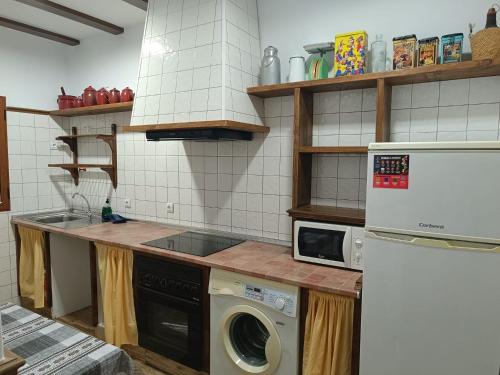 eine Küche mit einer Waschmaschine und einem Kühlschrank in der Unterkunft Casa Rural el Pajar Piscina para 3 apartamentos in Argamasilla de Alba