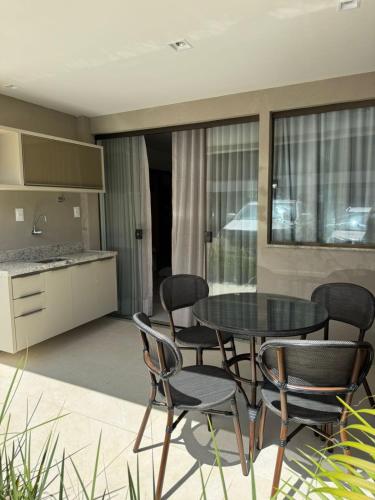 a kitchen and dining room with a table and chairs at Residencial TIE Praia de Guarajuba in Camacari