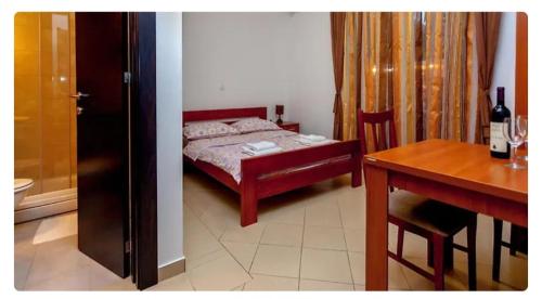 a bedroom with a bed and a table and a desk at Дарина in Igalo