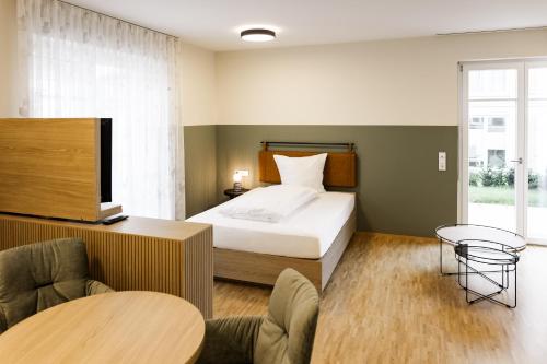 a bedroom with a bed and a table and chairs at Altes Bräuhaus, Ferienwohnungen und Apartments in Gaildorf in Gaildorf