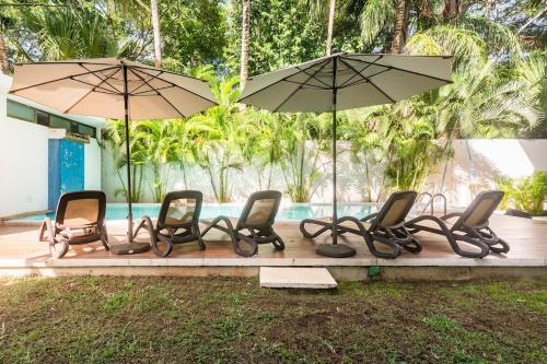 a group of chairs and umbrellas next to a pool at Experience tranquility and comfort accommodation, near main attractions in Riviera Maya in Lafitte