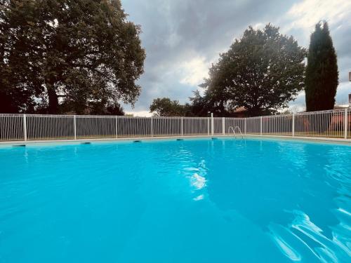 une grande piscine bleue avec une clôture dans l'établissement Appartement T2 dans une résidence avec piscine, à Toulouse