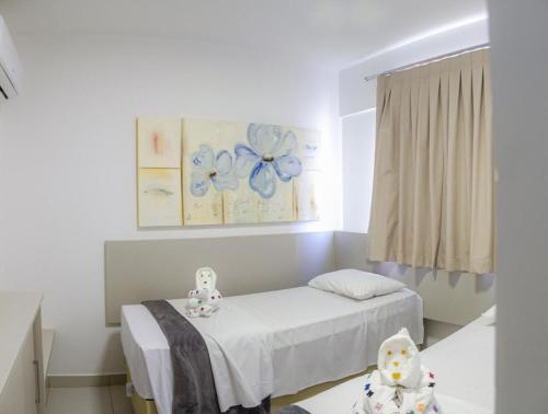 a hospital room with a bed and a flower painting at Evian Thermas Residence in Caldas Novas