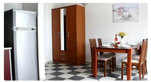 Un comedor con una mesa y un refrigerador. en Дарина, en Igalo