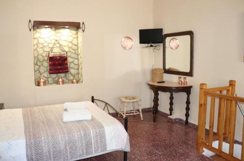 a bedroom with a bed and a mirror and a table at Mary's house in Makrikhórion