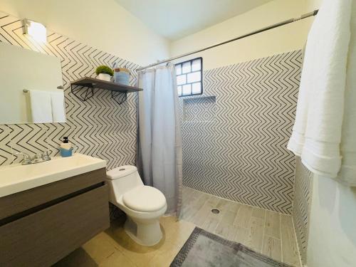 a bathroom with a toilet and a shower at Novaga Pto Morelos in Puerto Morelos