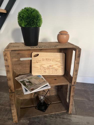 a wooden table with a potted plant on it at Gîte La Rive Gauche in Saint-Même-les-Carrières