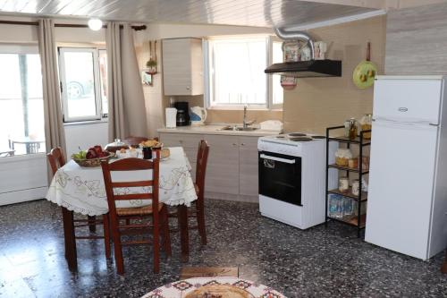 a kitchen with a table and a white refrigerator at Mary's house in Makrikhórion