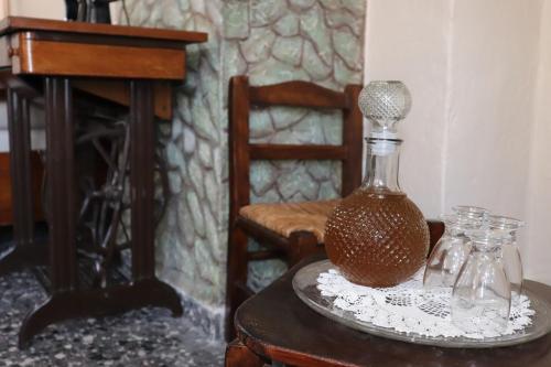 a glass bottle sitting on a table with a chair at Mary's house in Makrikhórion