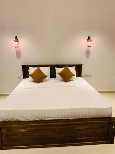 a bedroom with a bed with two lights on the wall at New Holiday Reach in Unawatuna