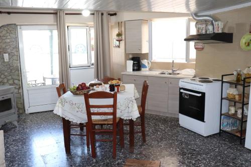 a kitchen with a table with chairs and a stove at Mary's house in Makrikhórion