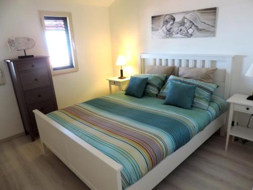 a bedroom with a large bed with blue pillows at Casa vacanze da Giovanni in Marina di Ragusa