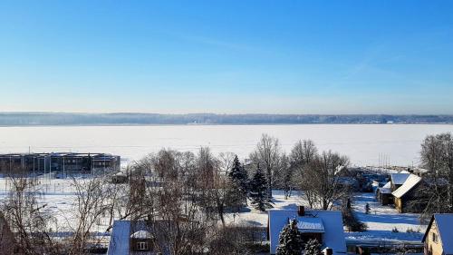 a view of a snow covered field and a lake at Apartment vanalinnas in Võru