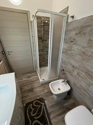 a bathroom with a shower and a toilet and a sink at Casa Alma in Porto Pino