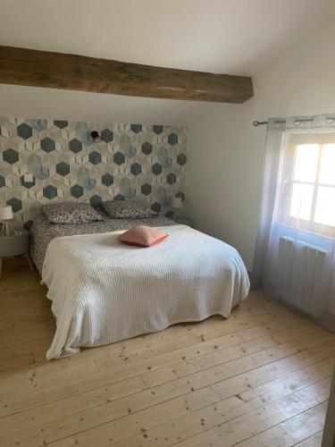 a bedroom with a white bed and a window at Gîte La Rive Gauche in Saint-Même-les-Carrières