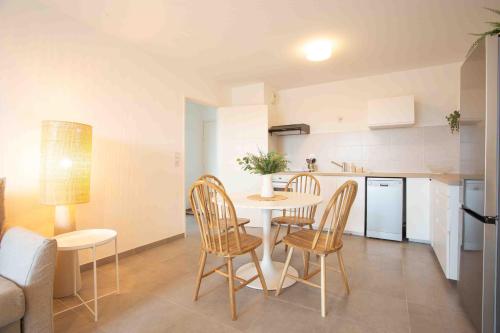 アヴィニョンにあるAppartement cosy - Agroparcのテーブルと椅子のあるキッチンとダイニングルーム