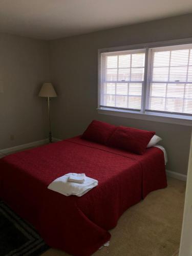 a bedroom with a large bed with a red bedspread at Private Master Queen Room in Winston-Salem