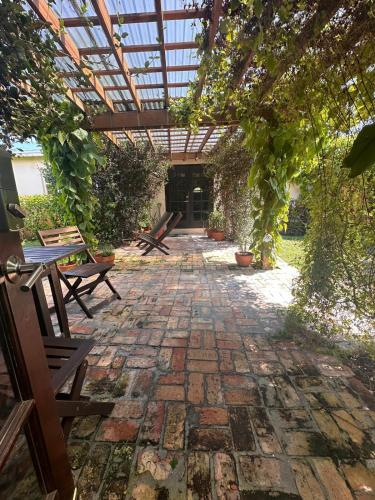 an outdoor patio with benches and a pergola at Kusikuy Private Guesthouse in Miami