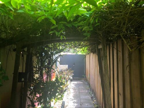 an alley with a fence and a gate with trees at Kusikuy Private Guesthouse in Miami