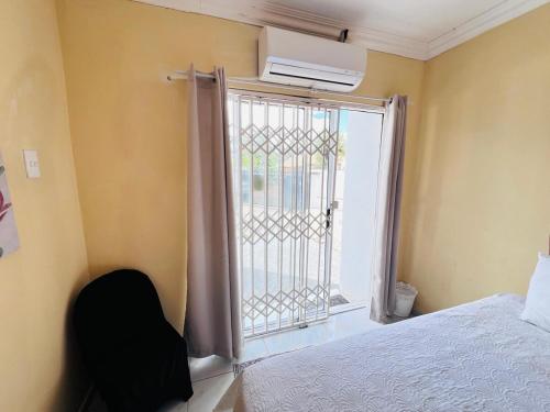 a bedroom with a bed and a window with a gate at Oteng Lifestyle BnB in Rustenburg